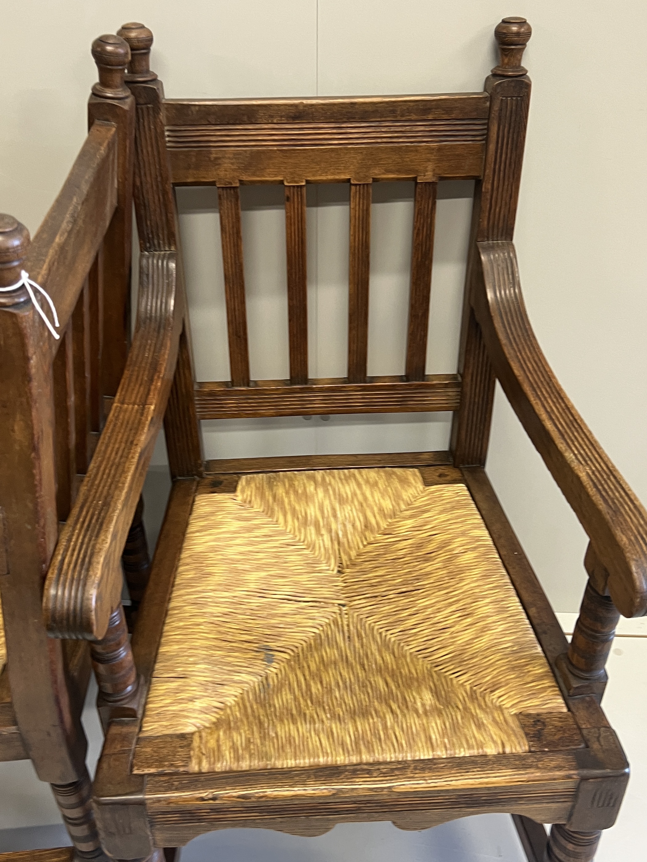 A pair of Victorian Arts & Crafts oak rush seat elbow chairs, width 58cm, depth 54cm, height 104cm